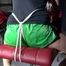 Watching sexy Sandra wearing a sexy green shiny nylon shorts and a black top being tied and gagged with ropes and a clothgag on a chair (Video)