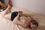 Amanda undresses and ties a man into hogtie and gag him