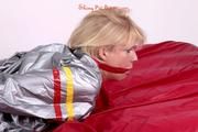 Pia tied and gagged in a shiny silver sauna suit bare feet on a bed (Pics)