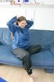 Katharina posing on a sofa wearing a blue/black shiny nylon rainwear (Pics)