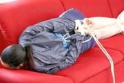 Jill tied, gagged and hooded with ropes on as sofa wearing a blue shiny nylon shorts and a blue oldschool rain jacket (Pics) 