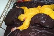 Stella tied and gagged in a shiny yellow rainsuit