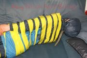 Katharina tied and gagged with tape on a sofa wearing shiny rainwear (Pics)