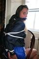 Stella tied and gagged on a chair wearing a blue shiny nylon shorts and a rain jacket (Pics)
