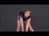 Brown-haired archive girl posing with an soccer ball wearing shiny nylon shorts and a rain jacket (Video)